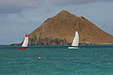 Sail boats passing by one of the Mokulua Islands at Lanikai Beach
